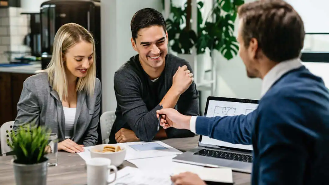 A happy couple smiling during a financial consultation in Canada about credit approval strategies.