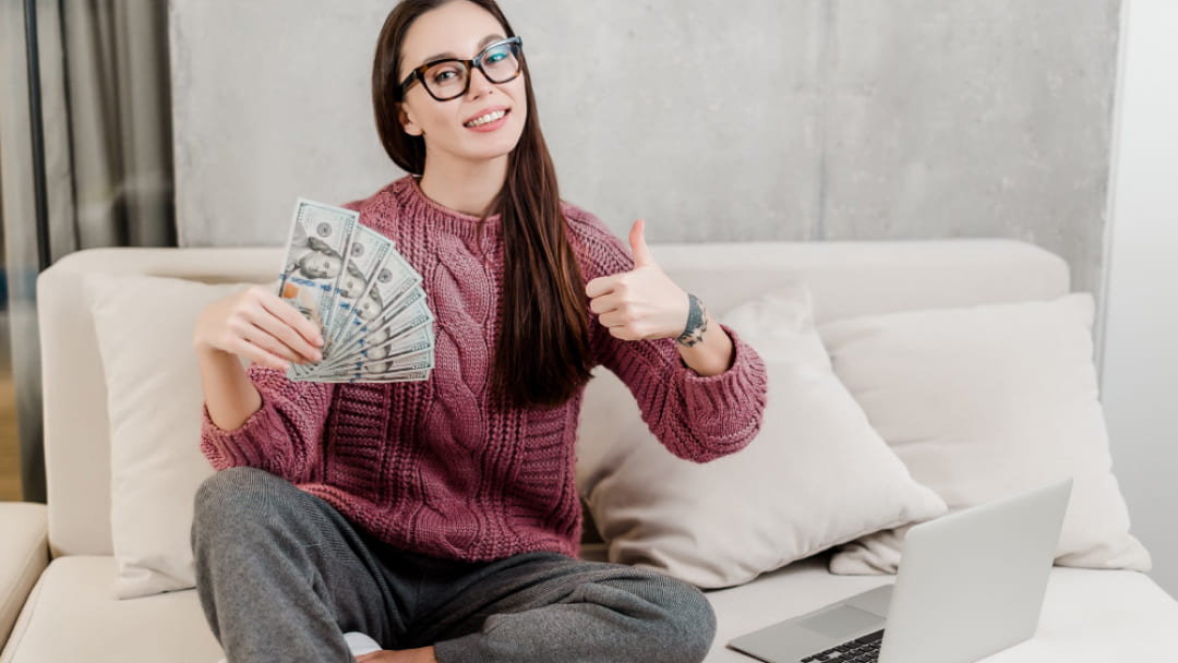 Person holding a loan agreement and money, discussing guaranteed loan options in Canada for 2026.